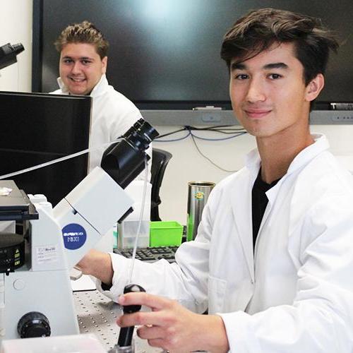 两名学生在Dr. 李的实验室.
